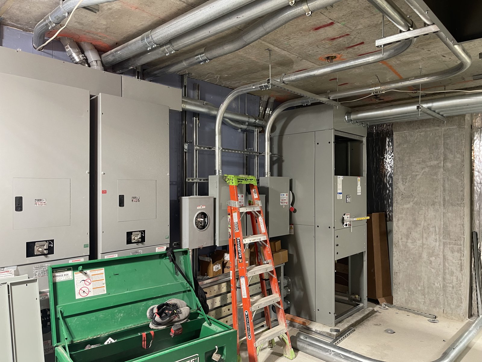 Electrical room installation with panels and overhead conduit